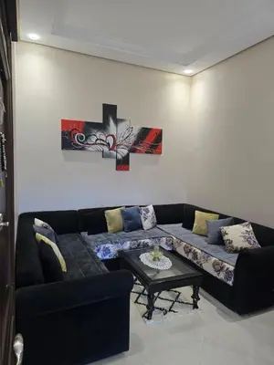 a living room with a couch and a table at Bel appartement in O Ben Slimane