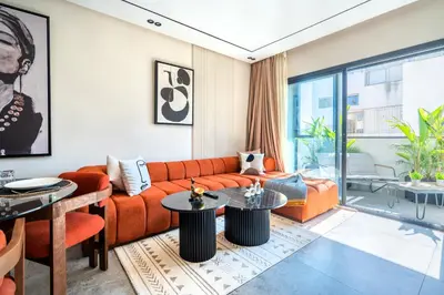 a living room with an orange couch and tables at CFC business, Coworking, gym, self check-in in Casablanca