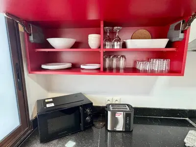 a kitchen counter with a microwave and some dishes at CityZen Suites, Luxury 3BR near Mohamed V Stadium in Maarif