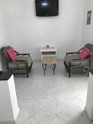 a room with two chairs and a table and a tv at Appartement cosy à Rabat Mer et commodités à pied in Rabat