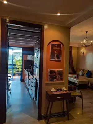 a kitchen and living room with a table in a room at Beach apartment with pool Skhirat beach in Skhirat