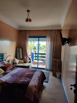 a bedroom with a bed and a view of a patio at Beach apartment with pool Skhirat beach in Skhirat