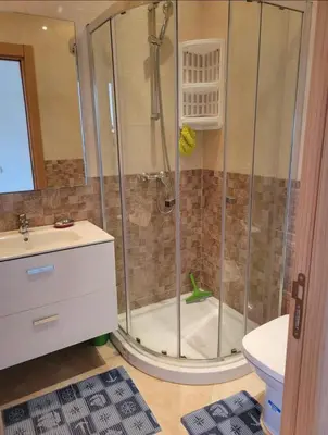 a bathroom with a shower with a toilet and a sink at Residence kettani in Bouznika