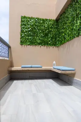 a green wall with two blue pillows on a bench at APGCI -Studio Élégant a 5 min du Stade Mohamed V in Casablanca