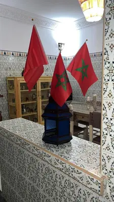 a table with a lantern with three flags on it at Villa Haryouli in Azemmour