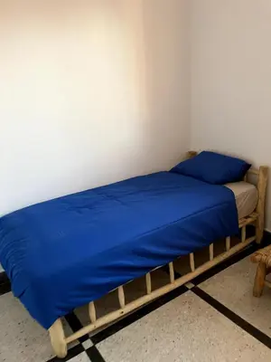 a bedroom with two beds with blue sheets at Villa Haryouli in Azemmour