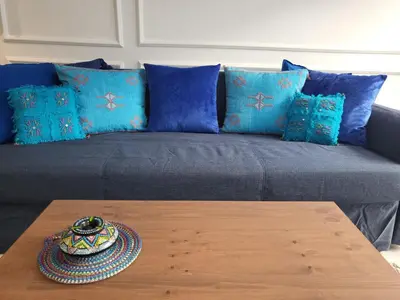 a couch with blue pillows and a tray on a table at O'Blu Pearl Casablanca Center, Morocco in Casablanca