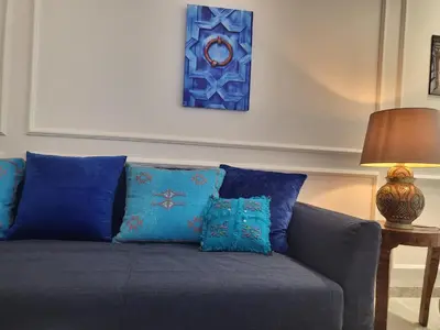 a couch with blue pillows in a living room at O'Blu Pearl Casablanca Center, Morocco in Casablanca