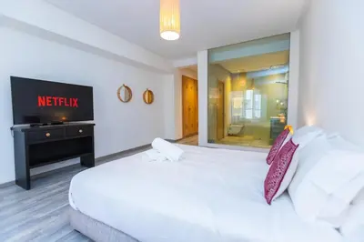 a bedroom with a white bed and a television at Luxury central Apartment - 3BR - Flipper - Parking in Casablanca