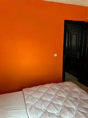 a bedroom with an orange wall and a bed at Studio cosy et abordable in Casablanca