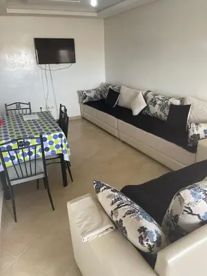 a living room with a couch and a table at Magnifique Appartement à Louer C14 Jnane Dalya in Bouznika