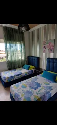 a bedroom with two beds with blue chairs at Appartement à louer Aux perles de tamaris in Tamaris