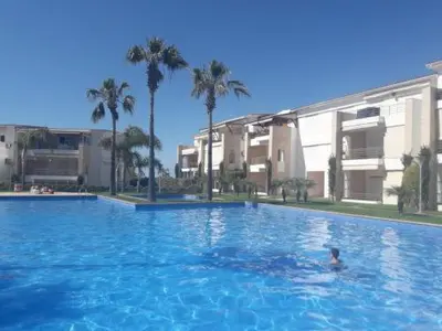 a person swimming in a large swimming pool at Appartement à louer Aux perles de tamaris in Tamaris