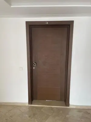 a wooden door in a room with a wall at Superbe Appartement à Louer C14 Jnane Dalya in Bouznika