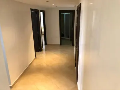 an empty hallway with doors and a tile floor at Superbe Appartement à Louer C14 Jnane Dalya in Bouznika
