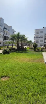 a park with palm trees and buildings in the background at appartement calme dt4 in Mohammedia