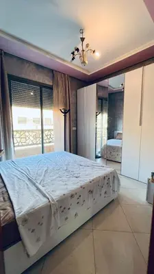 a bedroom with a large bed with a window at appartement calme dt4 in Mohammedia
