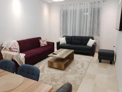 a living room with a couch and a coffee table at Les belles loges in Bouskoura