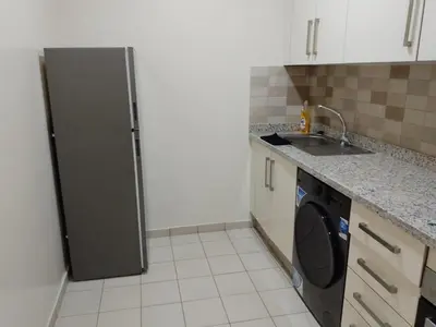 a kitchen with a refrigerator and a washing machine at Les belles loges in Bouskoura