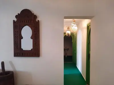 a hallway with a mirror on the wall and green floors at Casitademama in Sidi Yahia az Zaʼer