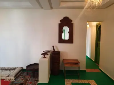 a living room with a table and a mirror at Casitademama in Sidi Yahia az Zaʼer