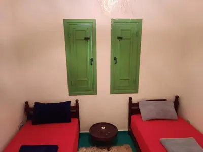 a room with two green doors and two beds at Casitademama in Sidi Yahia az Zaʼer