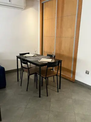 a black table with chairs and a wooden door at Appart hôtel las jemelas in Casablanca