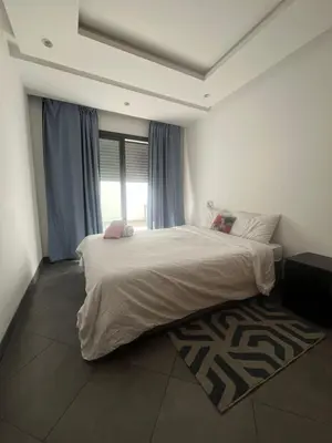 a bedroom with a large bed and a window at Appart hôtel las jemelas in Casablanca