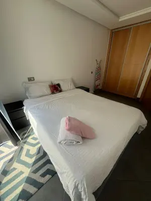 a white bed with a pink towel on it at Appart hôtel las jemelas in Casablanca