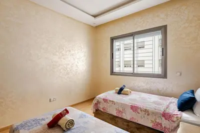 a bedroom with two beds and a window at 2ch au Centre de Mohammedia Parc in Mohammedia