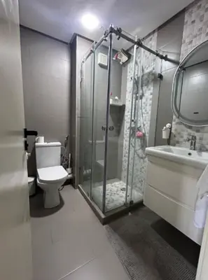 a bathroom with a shower and a toilet and a sink at Beach 1 min walk Pool Elevator Carrefour in O Ben Slimane