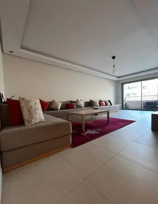 a living room with a couch and a table at Beach 1 min walk Pool Elevator Carrefour in O Ben Slimane