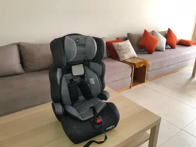 a car seat sitting on a table in a living room at Beach 1 min walk Pool Elevator Carrefour in O Ben Slimane