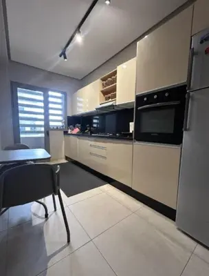 a kitchen with a table and a stove top oven at Beach 1 min walk Pool Elevator Carrefour in O Ben Slimane