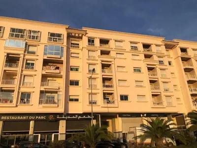 a large apartment building with palm trees in front of it at Park Plaza studio quiet comfort No one opposite in Mohammedia