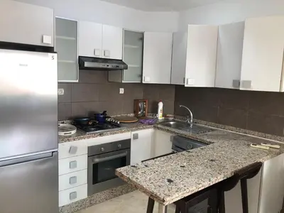 a kitchen with white cabinets and a granite counter top at Park Plaza studio quiet comfort No one opposite in Mohammedia
