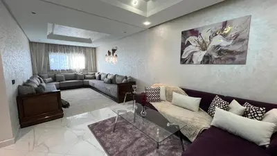 a living room with couches and a painting on the wall at Appartement Moderne et Lumineux in Rabat