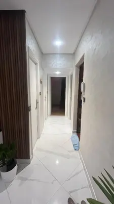 a hallway with a white tile floor in a building at Appartement Moderne et Lumineux in Rabat