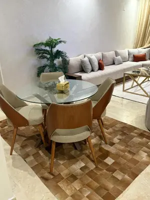 a living room with a glass table and a couch at Nice apartment with terrace overlooking pool in O Ben Slimane