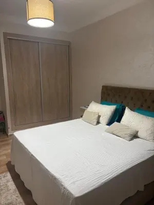 a bedroom with a large bed with white sheets and pillows at Nice apartment with terrace overlooking pool in O Ben Slimane