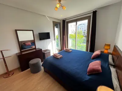 a bedroom with a blue bed with a large window at Modern 1BR Orangeraie - Terrace & Pool in Rabat