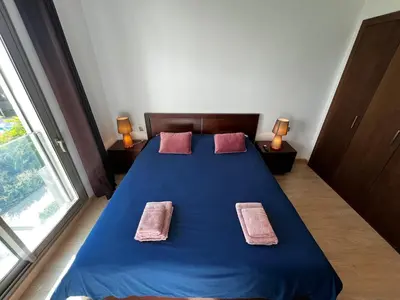 a bedroom with a blue bed with two pink pillows at Modern 1BR Orangeraie - Terrace & Pool in Rabat