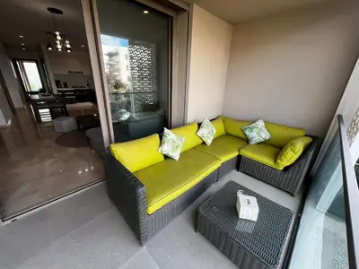 a living room with a couch with yellow cushions at Modern 1BR Orangeraie - Terrace & Pool in Rabat