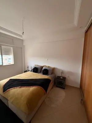 a bedroom with a large bed in a white room at Modern apartment in Rabat, Temara in Temara