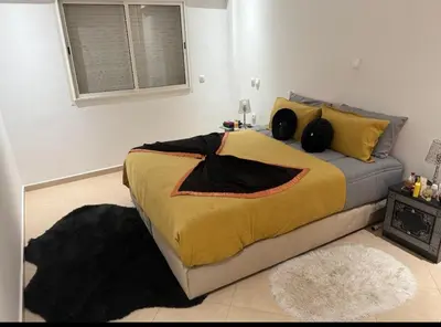 a bedroom with a bed with a yellow blanket at Modern apartment in Rabat, Temara in Temara