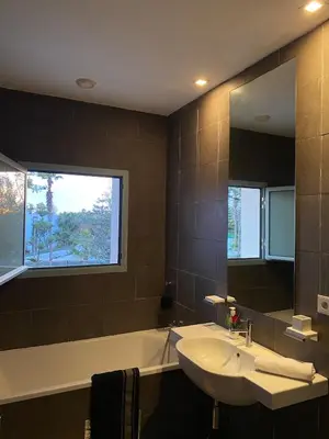 a bathroom with a sink and a mirror and a tub at Pearl Of Eden Island in Bouznika