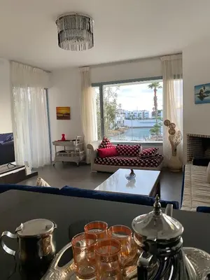 a living room with a couch and a table with glasses at Pearl Of Eden Island in Bouznika