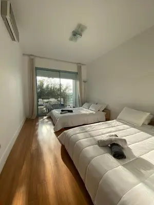 a bedroom with three beds and a large window at Pearl Of Eden Island in Bouznika