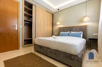 a bedroom with a large white bed with blue pillows at Prestige APT Style & elegant RABAT by MERAT HOME in Rabat
