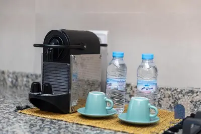 a coffee maker and two bottles of water on a counter at Prestige APT Style & elegant RABAT by MERAT HOME in Rabat